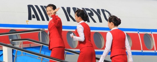 Azafatas saludando mientras entran en un avión de Air Koryo